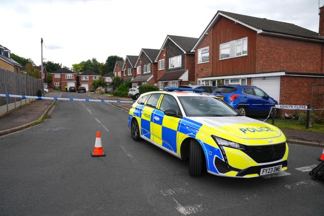 A police car in front of crime scene tape