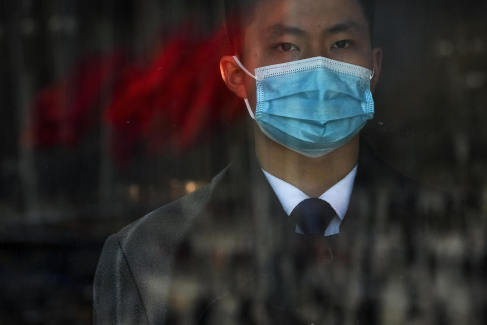 A soldier dressed as an usher stands guard at an entrance door of the Great Hall of the People during the second plenary session of the National People's Congress (NPC) in Beijing, Friday, March 8, 2024. (AP Photo/Andy Wong)