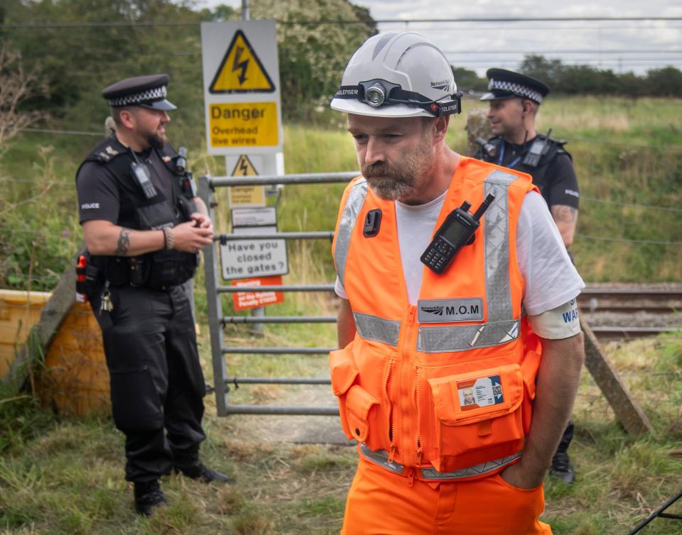 Police and railway workers near the scene in Balderton, near Newark-on-Trent. A police officer is in a serious condition after being hit by a train while trying to save a distressed man who was on the tracks. Nottinghamshire Police said officers were deployed to a residential area in Balderton just before 7pm on Thursday, over concerns for a man's safety. Picture date: Friday August 25, 2023.