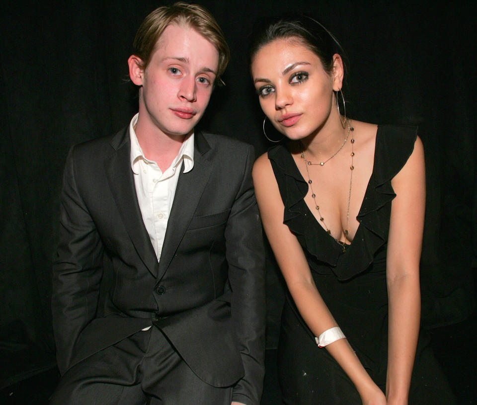 macaulay and mila sitting next to each other at a party