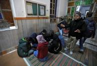 Students of the Jamia Milia University cover their faces as they take shelter in a mosque following a protest against a new citizenship law, in New Delhi