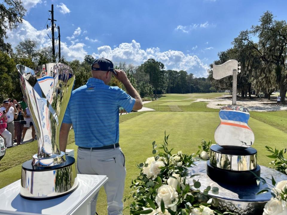 Furyk and friends tournament host Jim Furyk tips his hat to fans after being introduced on the first tee of the Timuquana Country Club in 2022 to start his round in the Constellation Furyk & Friends. The trophies are for winning the Charles Schwab Cup (left) and the Furyk & Friends.