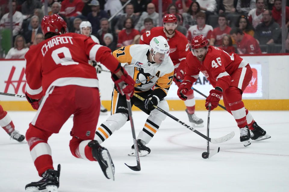 Pittsburgh Penguins center Evgeni Malkin (71) tries to carry the puck past Detroit Red Wings defenseman Jeff Petry (46) in the first period of an NHL hockey game Wednesday, Oct. 18, 2023, in Detroit. (AP Photo/Paul Sancya)