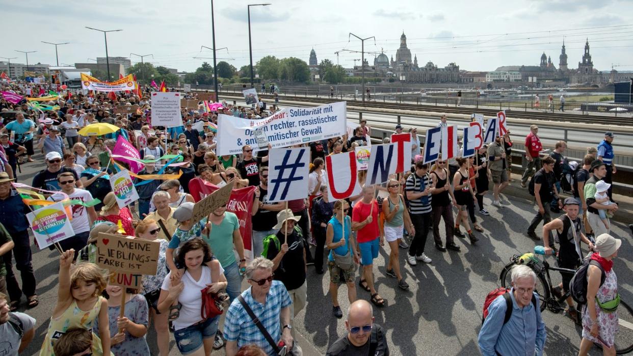 Vor der historischen Altstadtkulisse gehen Tausende Teilnehmer der Demonstration des Bündnisses #Unteilbar über die Carolabrücke in Dresden. Foto: Robert Michael