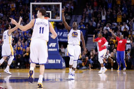 Jan 21, 2015; Oakland, CA, USA; Golden State Warriors center Andrew Bogut (12), guard Klay Thompson (11), and forward Draymond Green (23) celebrate after the Warriors' score against the Houston Rockets during the third quarter at Oracle Arena. The Warriors won 126-113. Mandatory Credit: Kelley L Cox-USA TODAY Sports