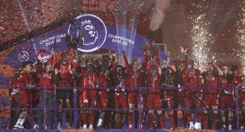 Liverpool's Jordan Henderson lifts the English Premier League trophy following the English Premier League soccer match between Liverpool and Chelsea at Anfield Stadium in Liverpool, England, Wednesday, July 22, 2020. Liverpool are champions of the EPL for the season 2019-2020. The trophy is presented at the teams last home game of the season. Liverpool won the match against Chelsea 5-3. (Phil Noble/Pool via AP)