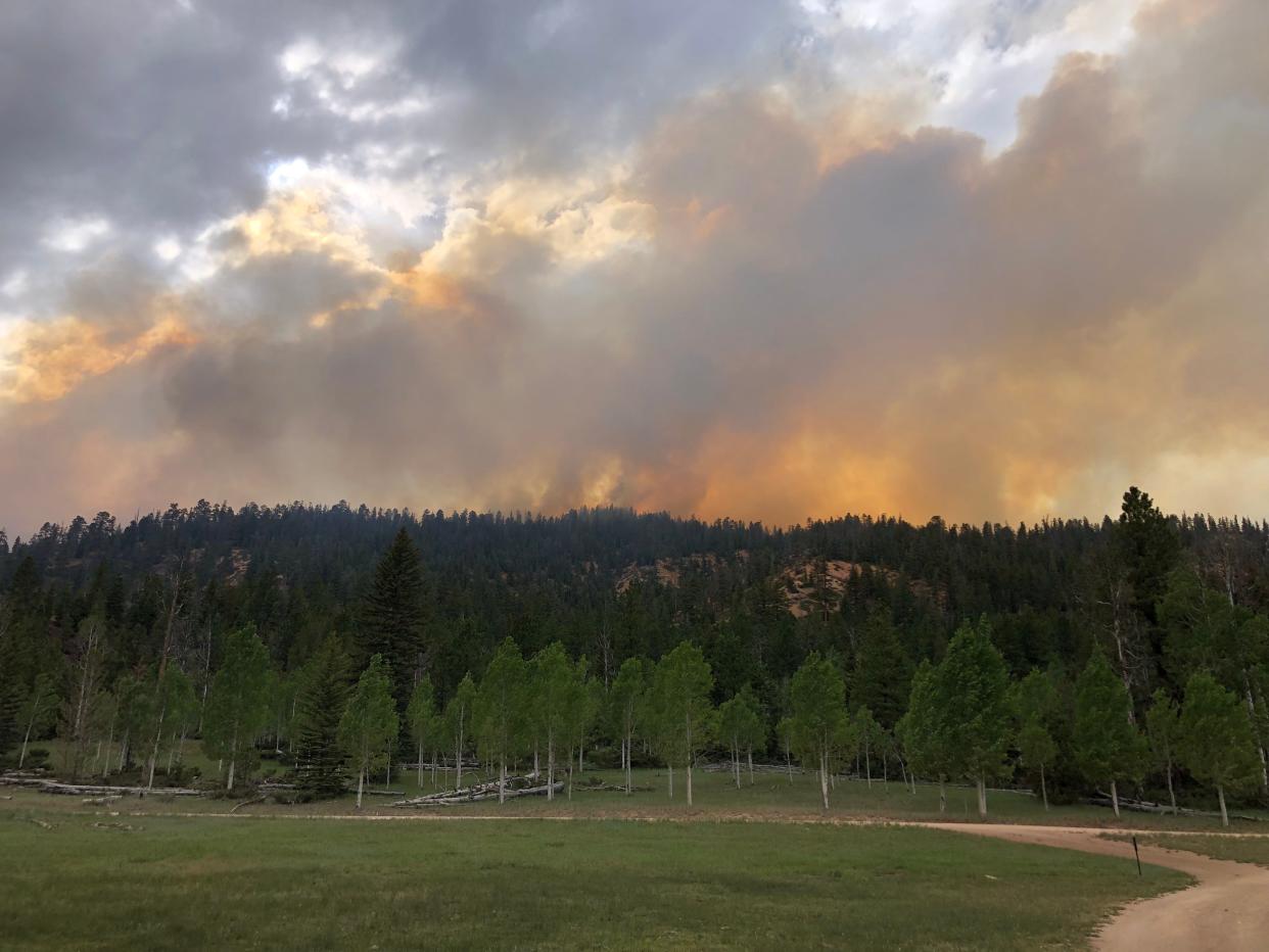 Smoke rises above the Left Fork Fire, which started in the mountains southwest of Bryce Canyon City on Saturday.