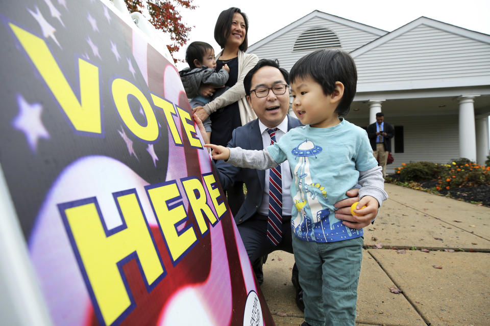 Then-candidate Andy Kim plays a word-game with his son as his wife, Kammy Lai, looks on with their younger son outside a polling place in Bordentown, N.J., on Nov. 6, 2018. (Mel Evans / AP file)