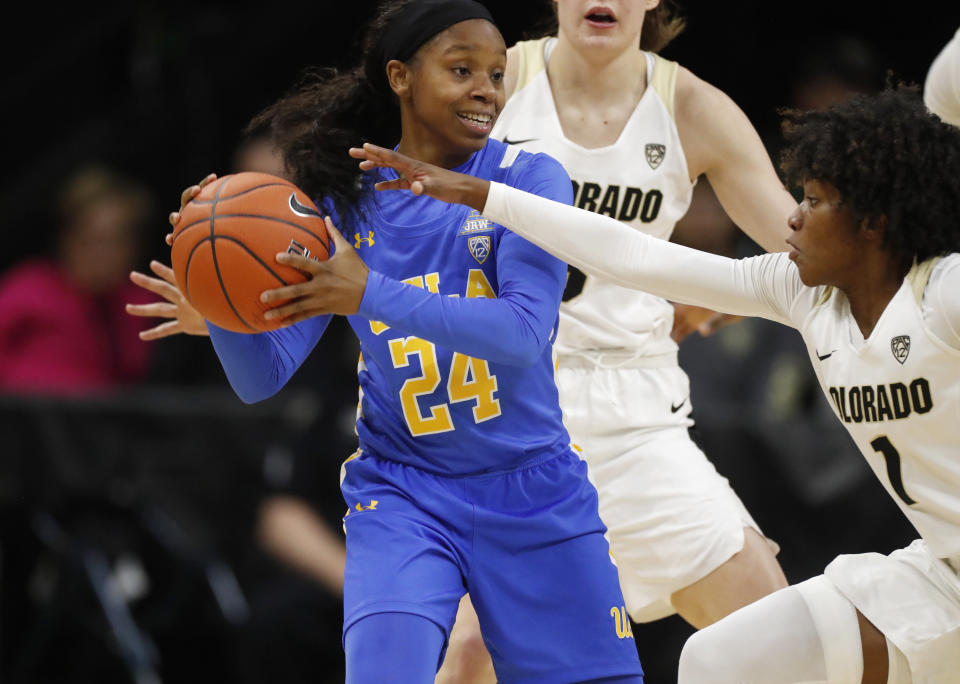 UCLA guard Japreece Dean, front left, looks to pass the ball as Colorado guards Jaylyn Sherrod, front right, and Emma Clarke defend in the first half of an NCAA college basketball game Sunday, Jan. 12, 2020, in Boulder, Colo. (AP Photo/David Zalubowski)