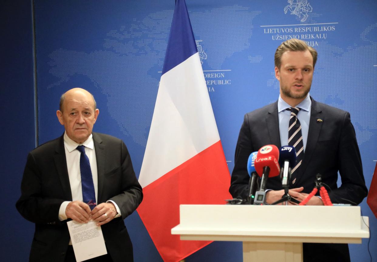 Lithuania's Foreign Minister Gabrielius Landsbergis, with beard and mustache, speaks as French Foreign Minister Jean-Yves Le Drian looks on.