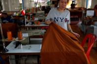 Foto del jueves de una mujer enrollando tela fabricada con plástico reciclado en un monasterio en Bangkok