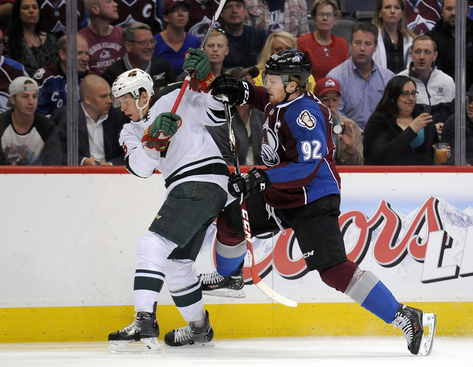 Colorado Avalanche left wing Gabriel Landeskog, right, of Sweden, checks Minnesota Wild left wing Erik Haula, left, of Finland, in the first period of Game 5 of an NHL hockey first-round playoff series on Saturday, April 26, 2014, in Denver. (AP Photo/Chris Schneider)