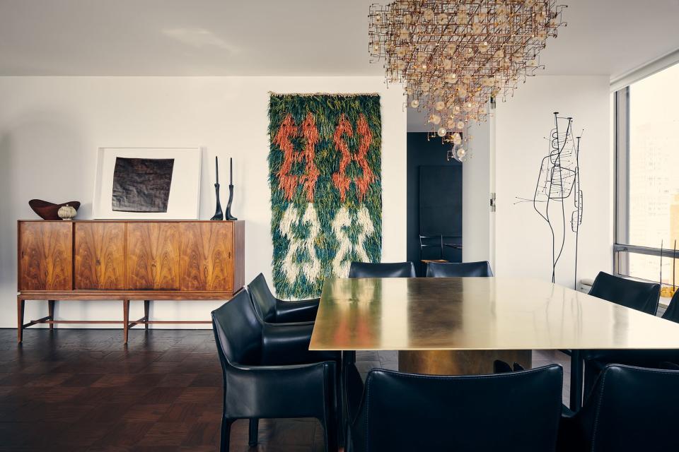 This 1,800-square-foot apartment at UN Plaza, a set of modernist towers built in 1966, is the home of architect David Mann and his partner, Fritz Karch, an author and collector of vintage and antique decorative objects. Mann, the founding partner of MR Architecture + Decor, lived in a Greenwich Village penthouse studio for 35 years before moving into this more “adult” space. A lighting sculpture by Studio Drift, made with real dandelion seeds, anchors the dining area. “It’s called Fragile Future, so I guess it will fall apart at some point, but it’s all still there,” jokes Mann. He commissioned a solid-brass table to go underneath it, pairing it with black leather armchairs by Mario Bellini for Cassina.