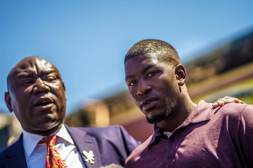 George Floyd's son, Quincy Mason Floyd (right) stands beside the family's lawyer Ben Crump (AFP via Getty Images)