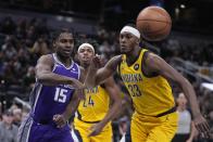 Sacramento Kings' Davion Mitchell (15) makes a pass against Indiana Pacers' Myles Turner (33) during the first half of an NBA basketball game, Friday, Feb. 3, 2023, in Indianapolis. (AP Photo/Darron Cummings)