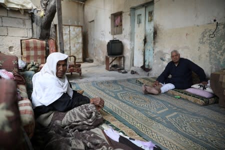 Palestinian refugee Mohammed Saleh and his wife sit at their home in Al-Baqaa Palestinian refugee camp, near Amman