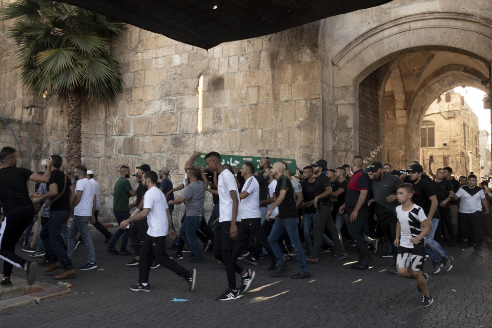 Palestinian protesters march into the Al Aqsa Mosque compound in the Old City of Jerusalem, Friday, Sept. 10, 2021. Amid increased Israeli-Palestinian tension over a recent prison break, Israeli police said an officer was lightly injured by a firearm in an attempt to thwart a suspected stabbing attack in the area. The Police, which arrested the suspect, did not immediately say how the officer was injured. (AP Photo/Maya Alleruzzo)