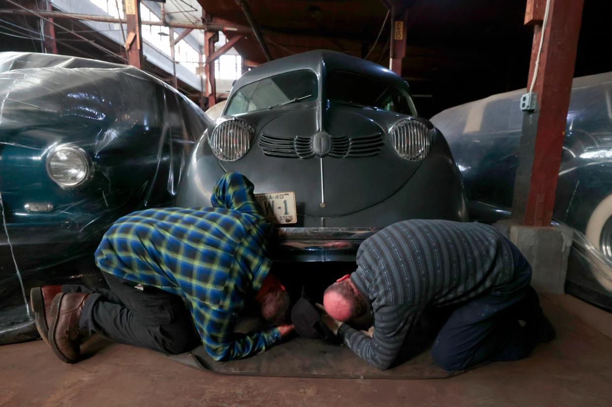 Dave Marchioni, 55, of St. Clair Shores and the industrial and automotive curator for the Detroit Historical Society, left, and Joe Tonietto, 67, of Troy, look to see how this 1934 Stout Scarab could be lifted up and taken to a built-in studio in the warehouse on Nov. 9, 2023. The Scarab is one of 60 vehicles that is kept in storage. The vehicles are occasionally rotated into exhibition at the Detroit Historical Museum on Woodward in Detroit. The Scarab was a car made in the Detroit area, at Scott Street and Telegraph in Dearborn. This one is one of six remaining with three of them in the state of Michigan. Two of those Scarabs are missing and there is an urban legend that one of them was used as a ice shanty and sank when the ice thawed.