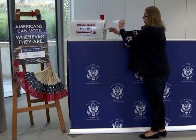 Patricia Wynn wears a protective mask as she casts an early ballot for the U.S. presidential  election at the U.S. Embassy in London, England, October 13, 2020. / Credit: REUTERS/Hannah McKaynn