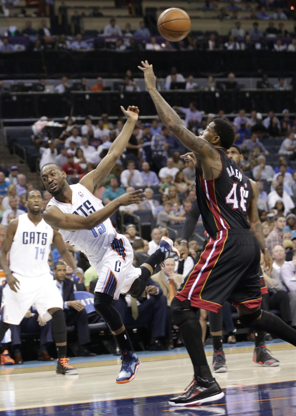 Charlotte Bobcats' Kemba Walker (15) is fouled by Miami Heat's Udonis Haslem (40) during the first half in Game 4 of an opening-round NBA basketball playoff series in Charlotte, N.C., Monday, April 28, 2014. (AP Photo/Chuck Burton)