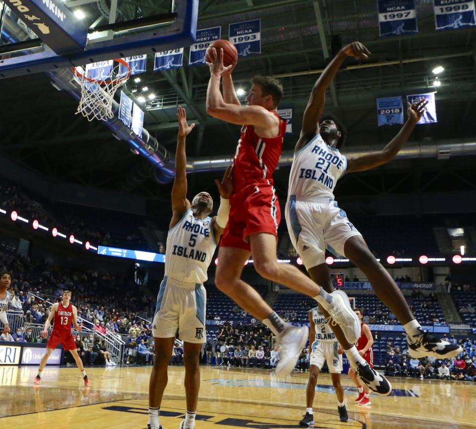 Davidson's Sean Mennenga gets inside URI's Antwan Walker, left, and Makhi Mitchell and grabs a rebound during Saturday's Atlantic 10 game at the Ryan Center.