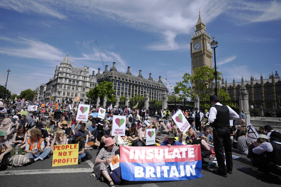 Members of environmental groups including Just Stop Oil, the Peace and Justice Project and Insulate Britain take part in a mass protest, in Parliament Square in London, Saturday, July 23, 2022. (AP Photo/Alessandra Tarantino)