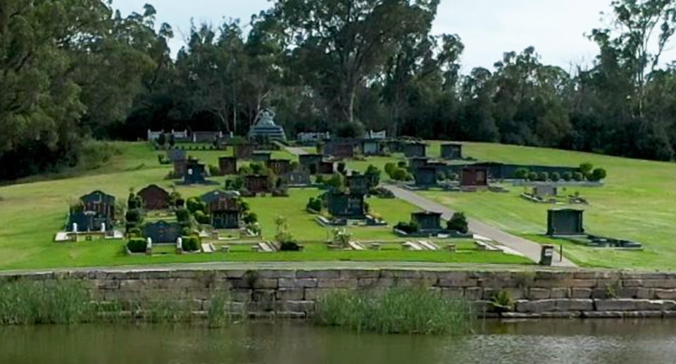Graves can be seen a Forest Lawn Memorial Park with water.