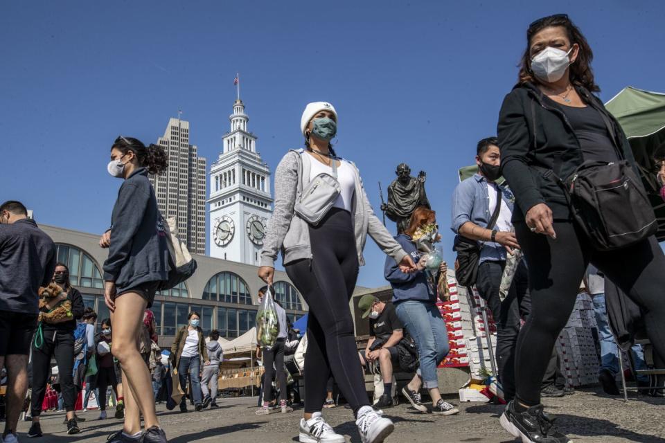 People walk along San Francisco's Embarcadaro.