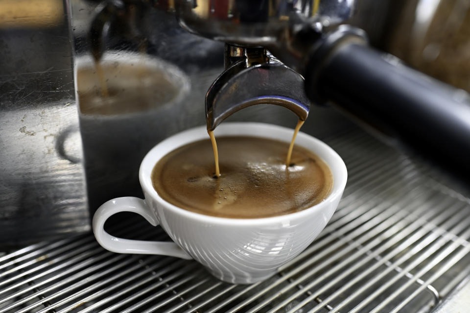 espresso being brewed into a coffee cup