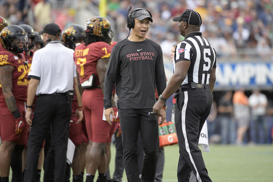 Iowa State wide receivers coach Nate Scheelhaase, center, talks to an official during a timeout in the first half of the Camping World Bowl NCAA college football game against Notre Dame Saturday, Dec. 28, 2019, in Orlando, Fla. (AP Photo/Phelan M. Ebenhack)