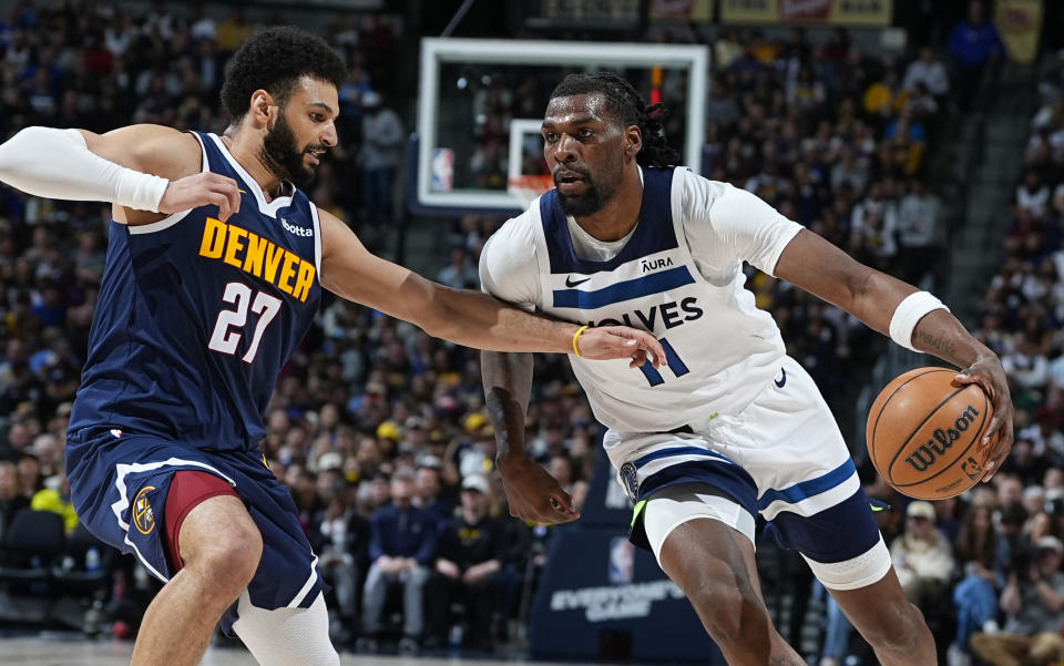 Minnesota Timberwolves center Naz Reid, right, drives against Denver Nuggets guard Jamal Murray during the second half of an NBA basketball game Wednesday, April 10, 2024, in Denver. (AP Photo/David Zalubowski)