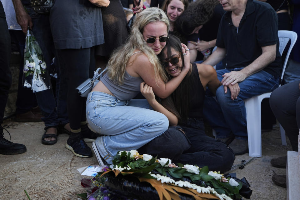 Israelis mourn next to the grave of Maya Puder, 25, during her funeral in Zikhron Ya'akov northern Israel, Thursday, Oct. 12, 2023. Puder and at least 260 more Israelis were killed by Hamas militants on Saturday at a rave near Kibbutz Re'im, as the militant Hamas rulers of the Gaza Strip carried out an unprecedented, multi-front attack that killed over 1,200 Israelis. (AP Photo/Ariel Schalit)