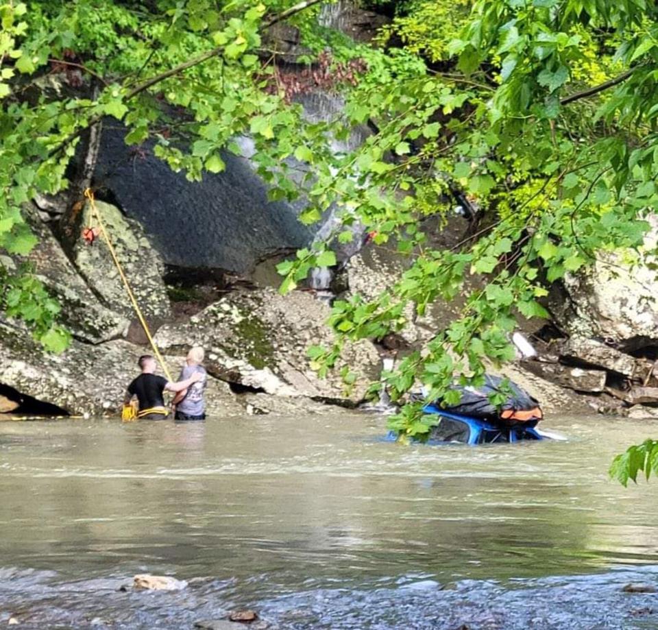 Crawford County Sheriff's Deputy Tyler Hines (left) helps Mark Girdner out of the water at Natural Dam, Arkansas. Girdner misread the trail and drove off a 30-foot bluff into the flooded creek. Girdner's Bug landed upright, but he was submerged in cold water for nearly 30 minutes.