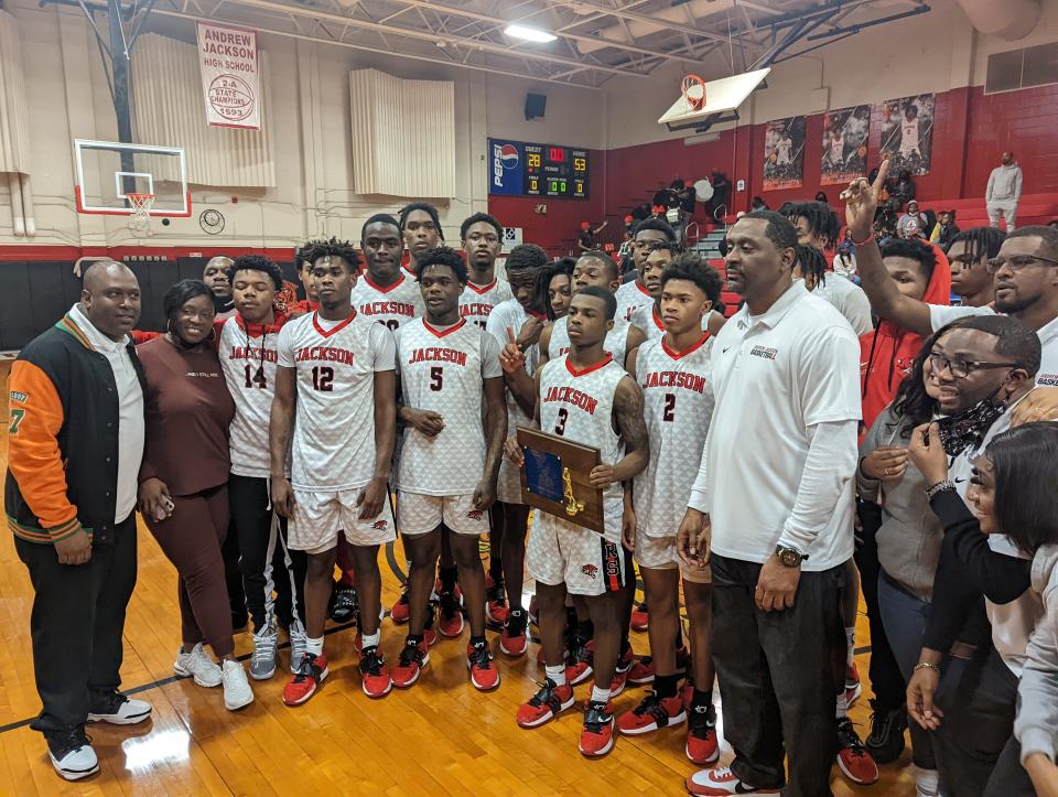 Jackson's boys basketball team celebrates with the trophy after defeating Paxon for the Gateway Conference high school championship on January 28, 2022. [Clayton Freeman/Florida Times-Union]