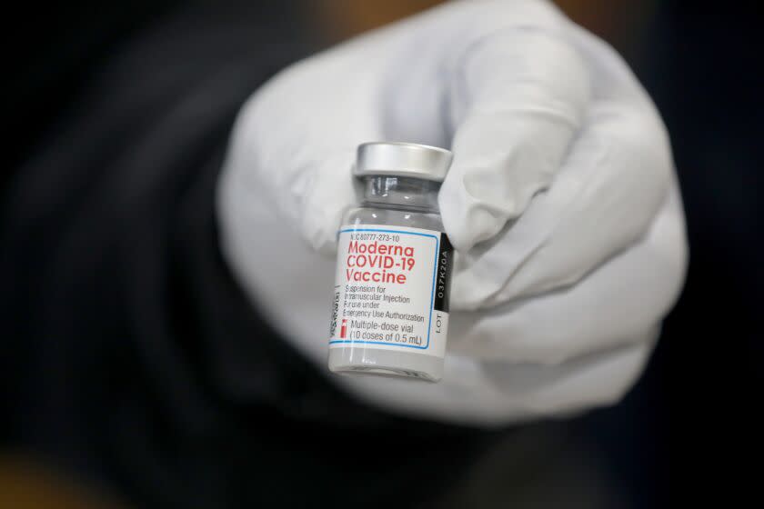 LOS ANGELES, CA - DECEMBER 28: Michael Contreras, Los Angeles Fire Department (LAFD) firefighter paramedic, holds a Moderna COVID-19 vaccination to be given to LAFD personnel at Station 4 on Monday, Dec. 28, 2020 in Los Angeles, CA. Mayor of Los Angeles Eric Garcetti and Ralph M. Terrazas, LAFD fire chief, were there to observe the rollout of the vaccination program. (Gary Coronado / Los Angeles Times)