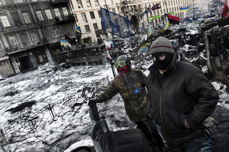 Anti-government protesters stand at a road block in Kiev on January 30, 2014