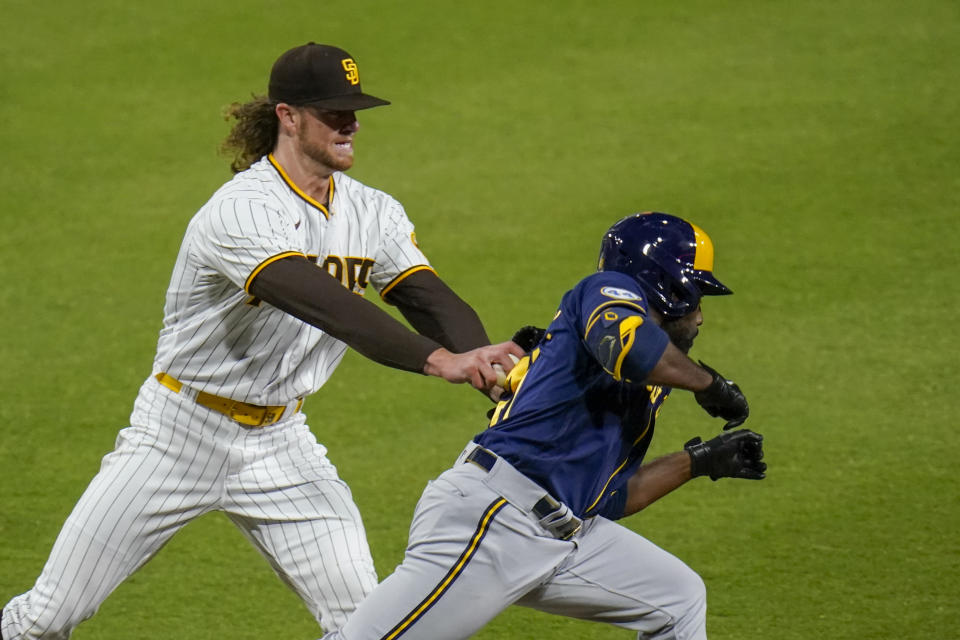 San Diego Padres starting pitcher Chris Paddack tags out Milwaukee Brewers' Jackie Bradley Jr. during the third inning of a baseball game Tuesday, April 20, 2021, in San Diego. (AP Photo/Gregory Bull)