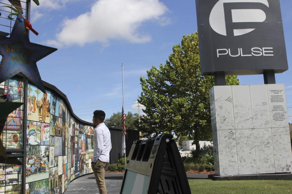 Brandon Wolf, a survivor of the Pulse nightclub shooting and activist, looks at the photos that are a part of the Pulse memorial in Orlando, Fla., on Sept. 9, 2022. / Credit: Cody Jackson/AP