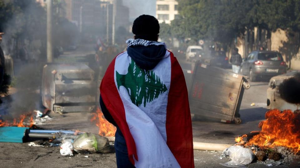 Un manifestante antigubernamental portando la bandera del país-