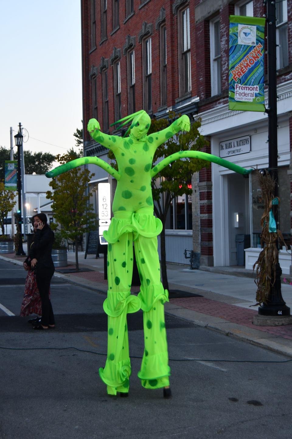 GLOvation Alien on stilts walks toward people at the Crop Circle.