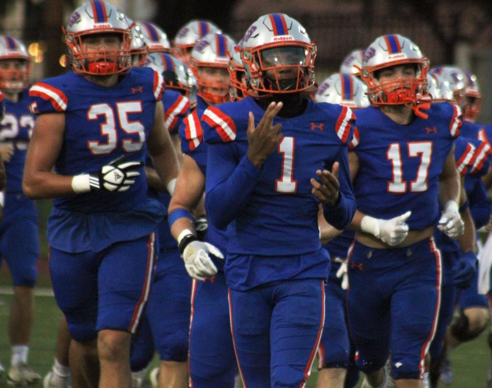 Bolles quarterback DJ Moore (1) leads teammates onto the field for a high school football game against Trinity Christian on September 15, 2023. [Clayton Freeman/Florida Times-Union]