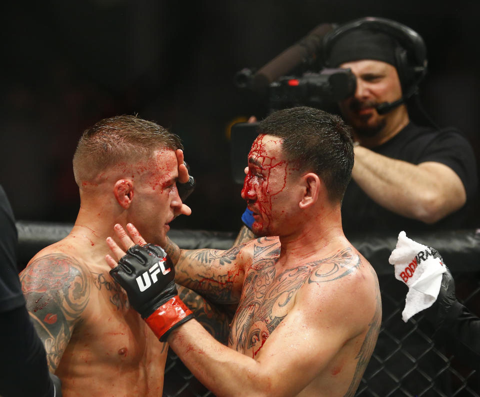 Max Holloway, right, and Dustin Poirier acknowledge one another during an interim lightweight title mixed martial arts bout at UFC 236 in Atlanta, early Sunday, April 14, 2019. (AP Photo/Michael Zarrilli)
