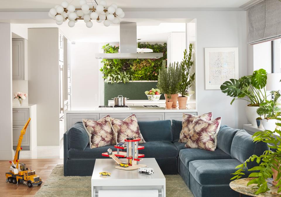 In an NYC Park Avenue co-op apartment owned by a married pair of clients with dissimilar styles, designer Brock Forsblom embraced an open plan for the family room, kitchen, and breakfast room. “Suddenly everything feels sexy and young and livable,” Forsblom says. The blue mohair velvet Milo Baughman sofa is the clients’ own; the chandelier is contemporary Italian from the Paris flea market. Train table from Ducduc. Custom Moroccan wool rug from Rug & Kilim.