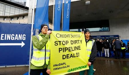 Activists of environmental group Greenpeace display a poster to protest against the financing of the Dakota-Access oil pipeline ahead of Swiss bank Credit Suisse?s annual shareholder meeting in Zurich, Switzerland April 28, 2017. REUTERS/Arnd Wiegmann