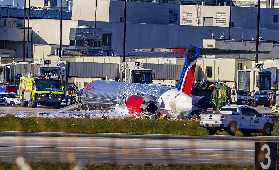 Firefighting units are seen next to a Red Air plane that caught fire after the front landing gear collapsed upon landing at Miami International Airport in Miami, after arriving from Santo Domingo, Dominican Republic, Tuesday, June 21, 2022. (Pedro Portal/Miami Herald via AP)