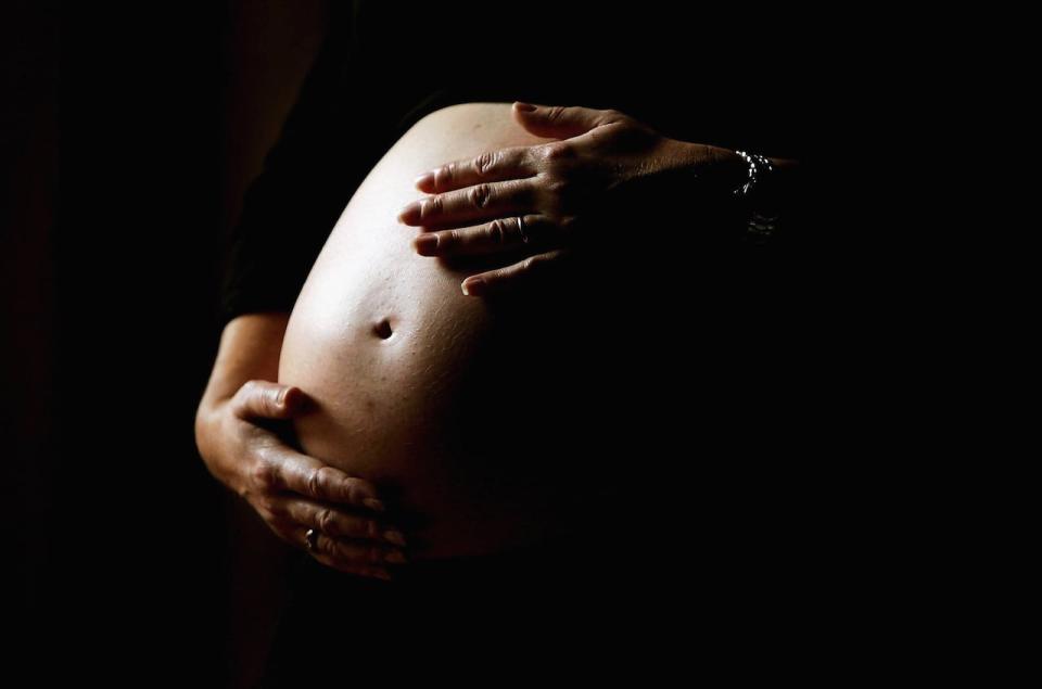 SYDNEY, NSW - JUNE 07:  A pregnant woman holds her stomach June 7, 2006 in Sydney, Australia. Australia is currently enjoying a baby boom, with the Australian Bureau of Statistics registering a 2.4% increase in births from 2004 to 2005, which represents the highest number of births since 1992. The Australian Federal Government has been encouraging people to have more babies, with financial incentives and the slogan by treasurer Peter Costello to "have one for mum, one for dad, and one for the country". The Federal Government has identified falling fertility rates and the ageing population as long-term problems for Australia's growth and prosperity.  (Photo by Ian Waldie/Getty Images)