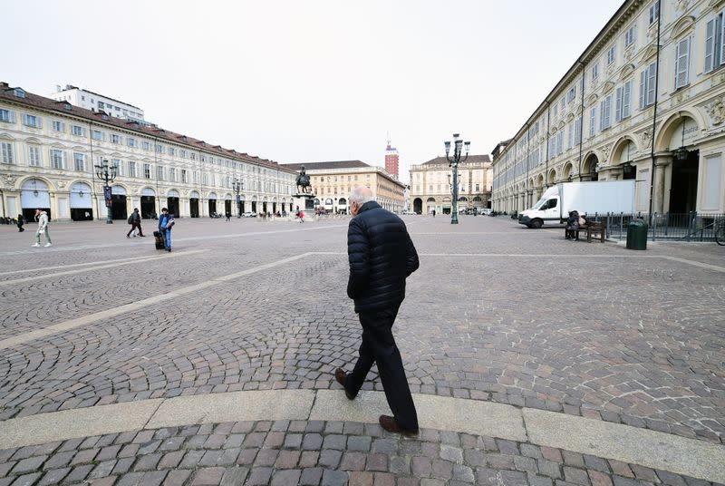 A man walks in San Carlo square, as a coronavirus outbreak continues to grow in northern Italy, in Turin