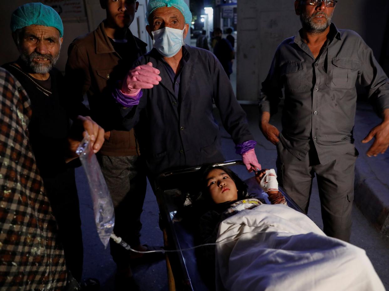 injured school girl waits by hospital in Kabul Afghanistan