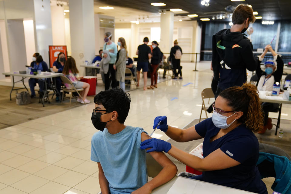 Manaf Albarakati, 14, of Narberth, Pa., receives a Pfizer COVID-19 vaccination from registered nurse Alicia Jimenez at a Montgomery County, Pa., Office of Public Health vaccination clinic at the King of Prussia Mall, Tuesday, May 11, 2021, in King of Prussia, Pa.. (AP Photo/Matt Slocum)