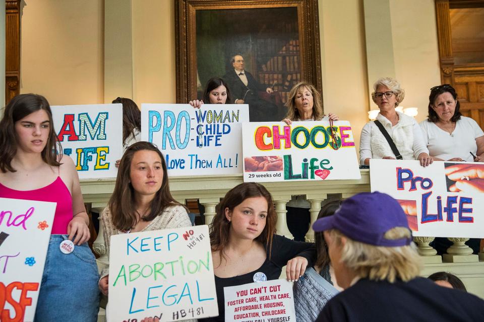 Pro-abortion rights and anti-abortion demonstrators display their signs in the lobby of the Georgia State Capitol.